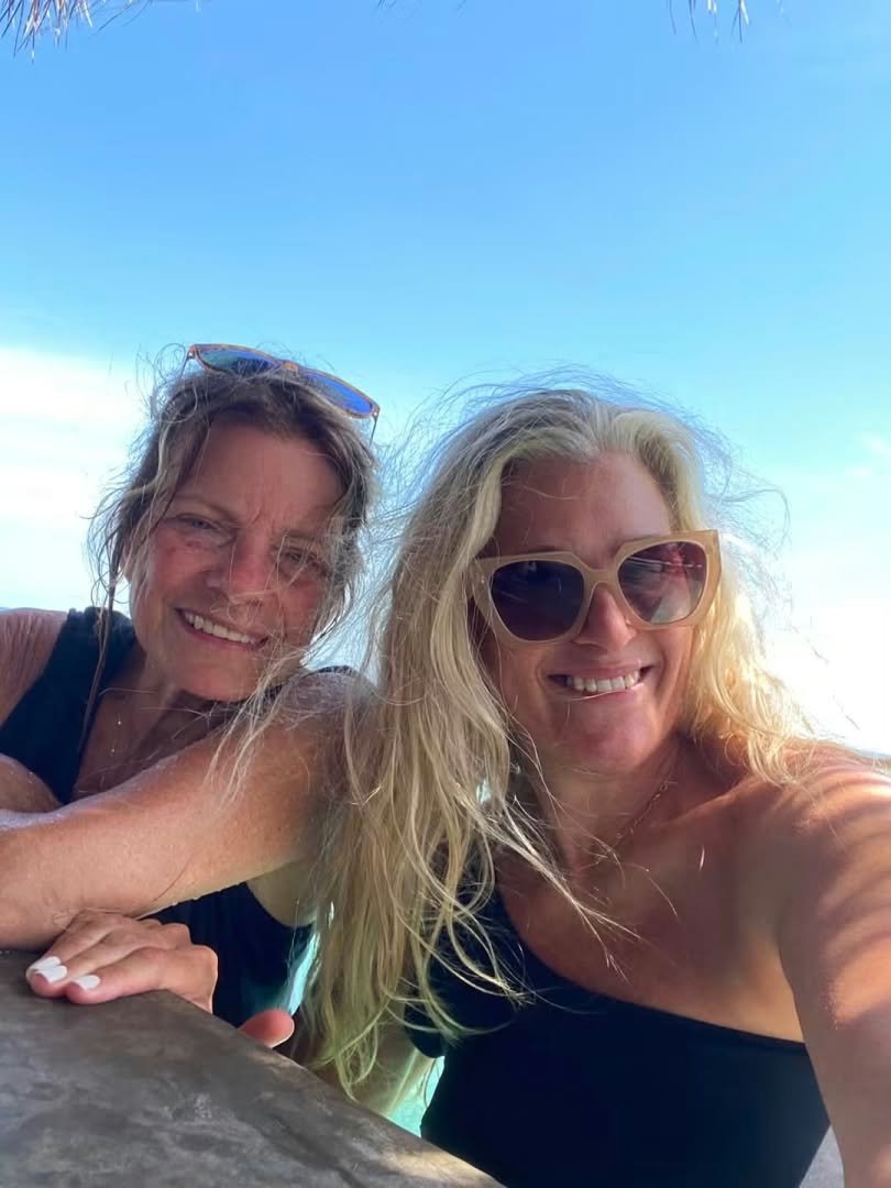 Cynthia and Mary smiling together outdoors